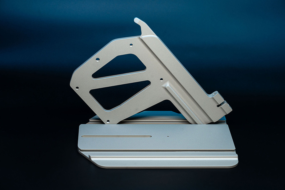 Zwei eloxalähnlich beschichtete Aluminiumbauteile als Kombination aus Träger- und Montageelement.