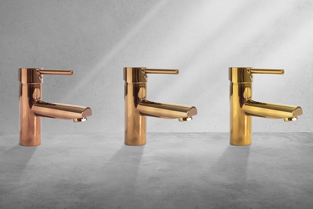 Drei glänzende Waschtischarmaturen in unterschiedlichen metallischen Farbtönen – Kupfer, Bronze und Gold – auf Betonhintergrund, als Beispiel für hochwertige, farblich individualisierte Sanitärbeschichtungen.