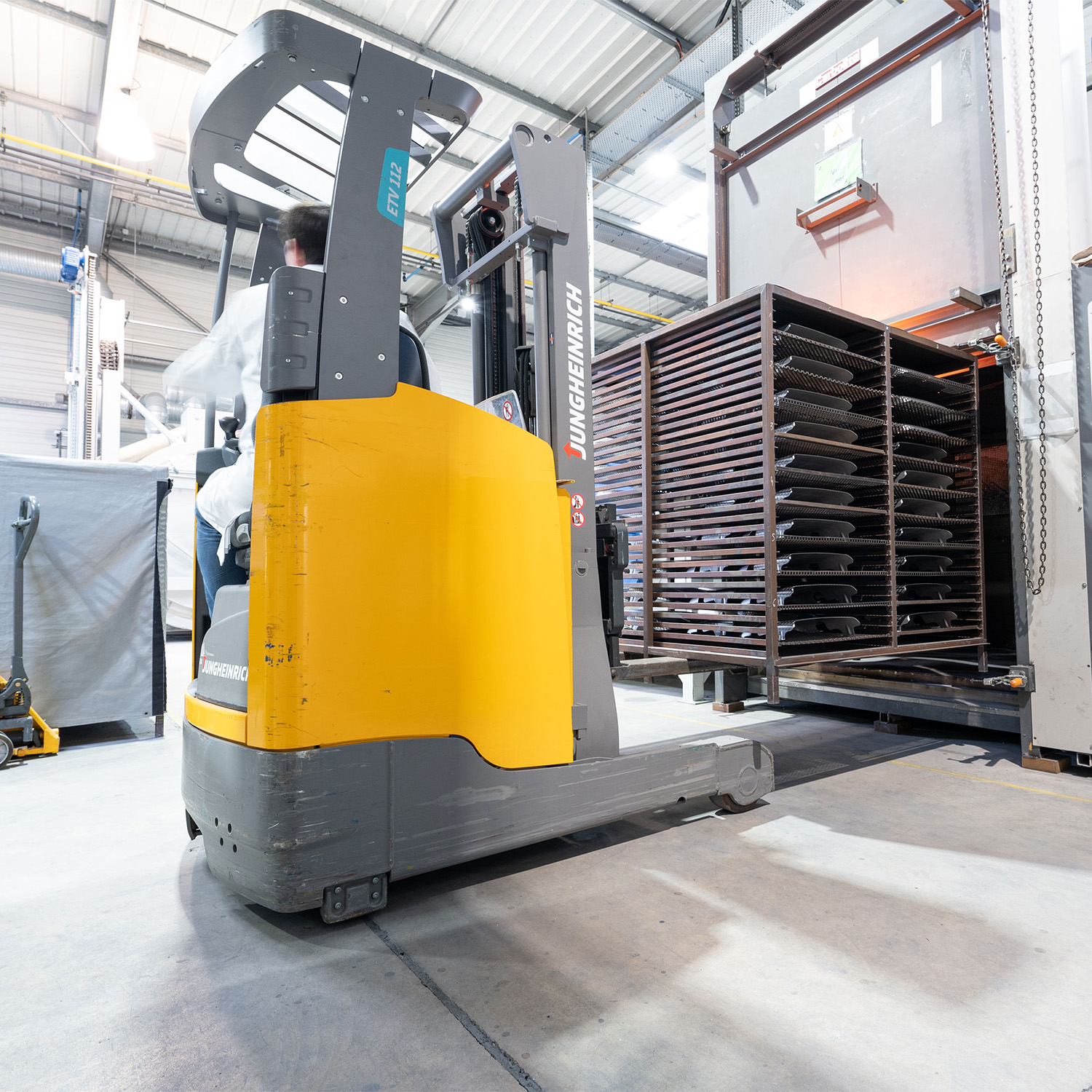 Industrial production with forklift loading coated components into the oven.